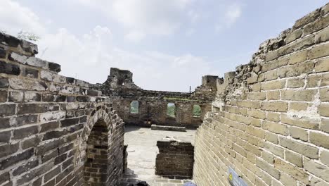 Two friends navigate a steep section of the Great Wall of China on all fours, sweat dripping