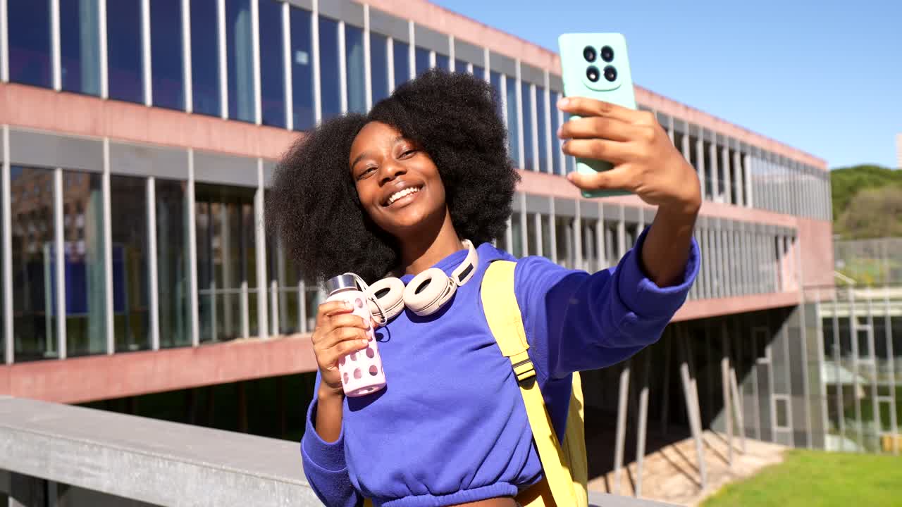 Glad ung kvinde tager en selfie på universitetscampus