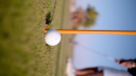 Detail-Des-Golfballs,-Der-Von-Einem-Kaukasischen-Mann-In-Ein-Golfloch-Gelangt