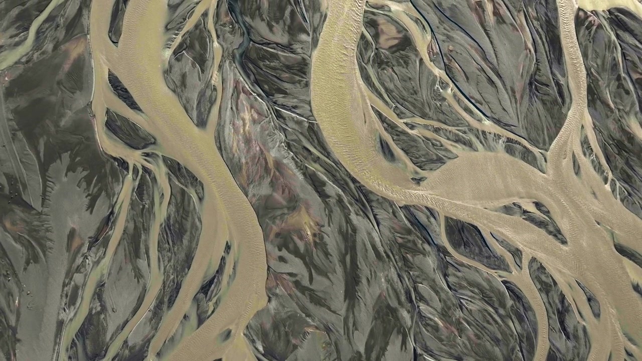 Aerial overview over natural formations of a river delta, sunny day in Iceland