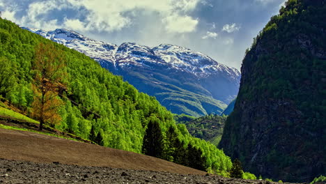 Densas-Nubes-Dinámicas-Que-Emergen-Sobre-El-Pico-Nevado-De-La-Montaña-En-El-Desierto-De-Noruega-Durante-El-Día-Soleado,-Lapso-De-Tiempo-Desde-La-Cima-De-La-Montaña