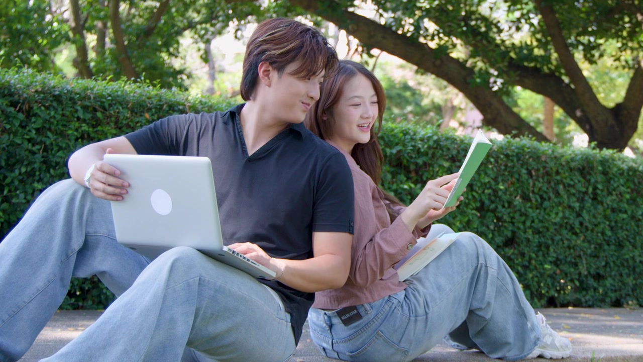 Young Asian Couple Studying Together in Park with Laptop and Book
