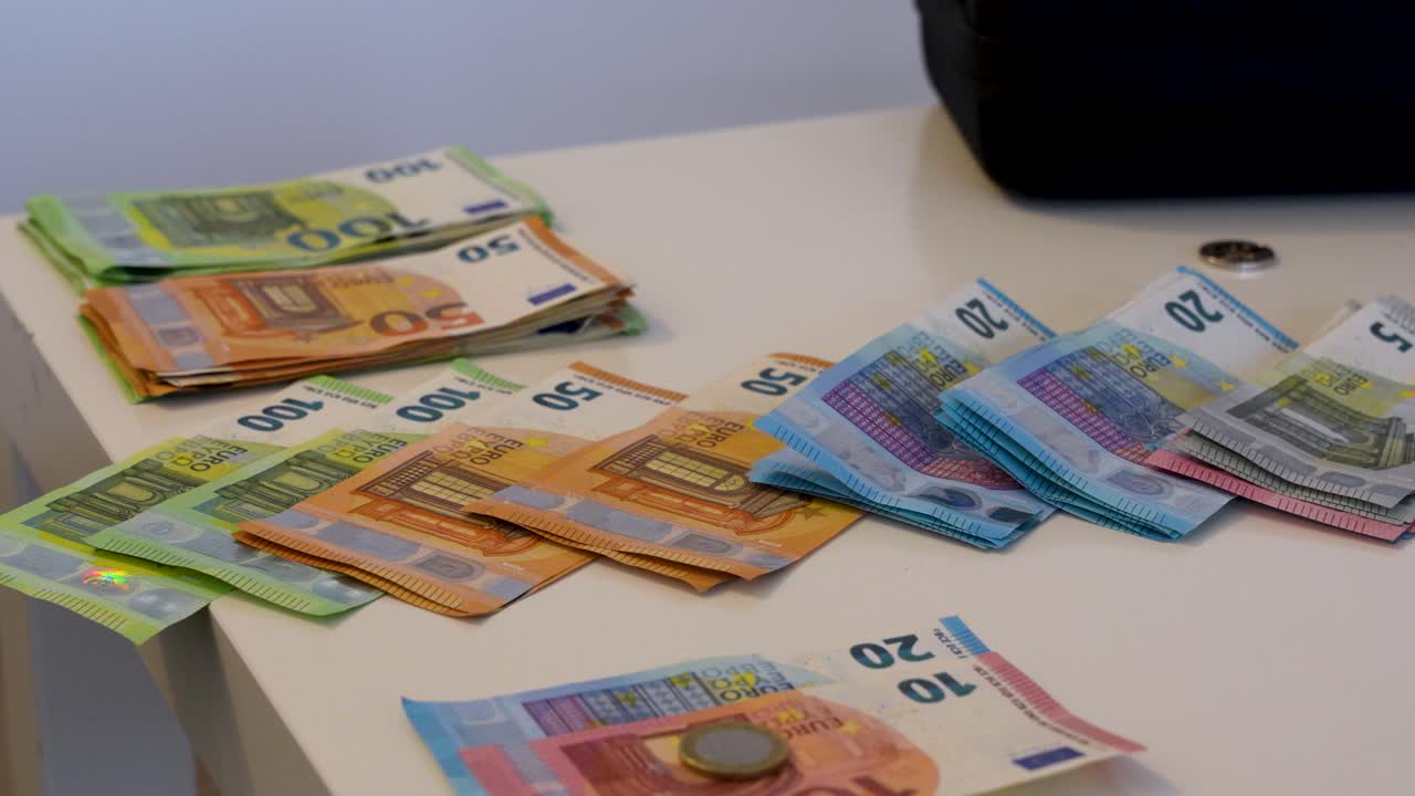 Stapel von europäischen Euro-Banknoten und -Münzen, die auf einem Schreibtisch angeordnet sind und Finanzen, Bankwesen, Investitionen, Sparen und wirtschaftlichen Währungsumtausch symbolisieren