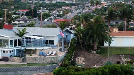 drone pans past cliff side real estate in residential suburban san pedro to reveal white point park and the pacific ocean in los angeles country, california