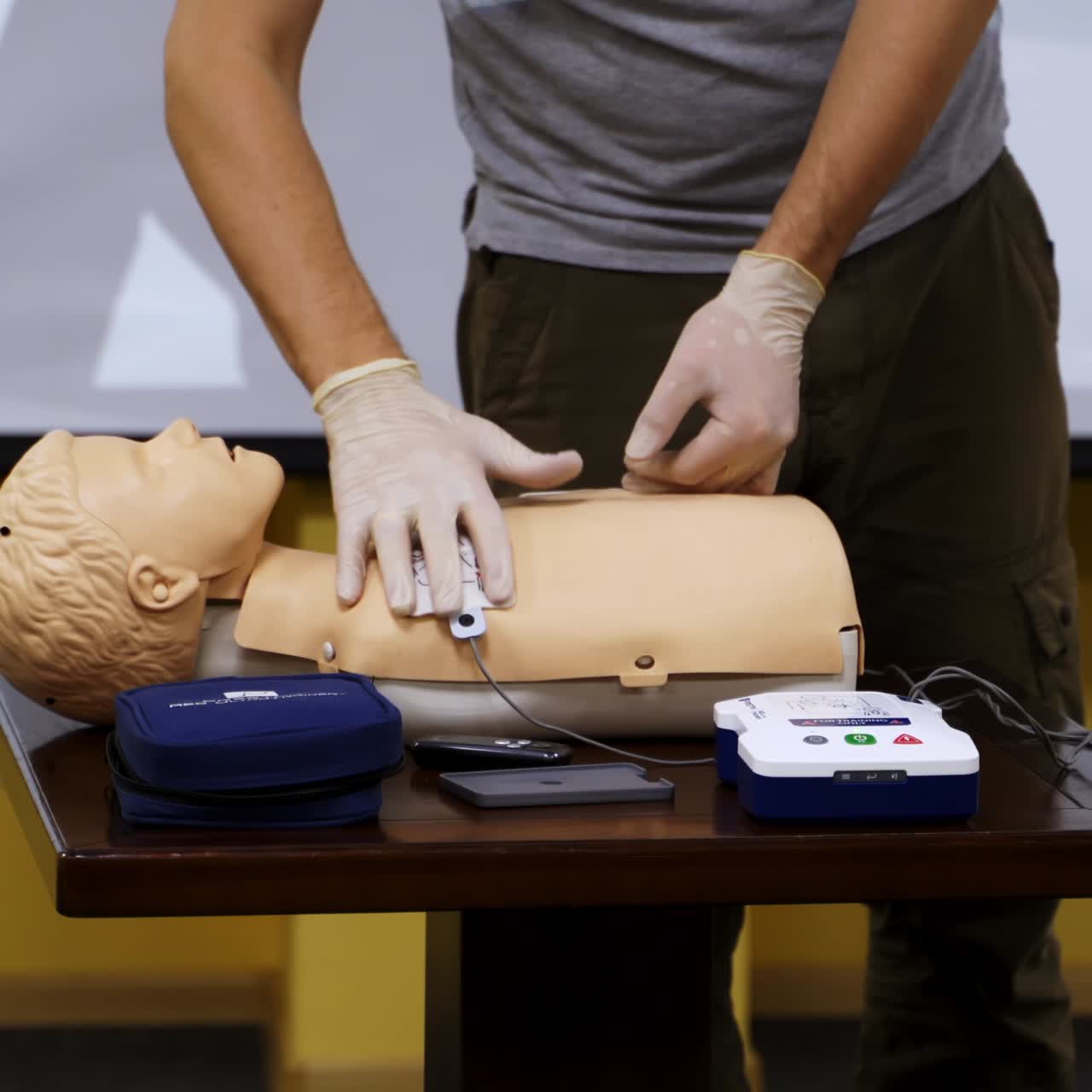 Practical advices for first aid on a mannequin. Trainer demonstrating on a dummy in emergency situation. Training course