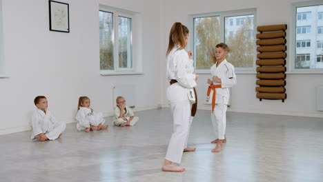 kids in white kimono in martial arts class