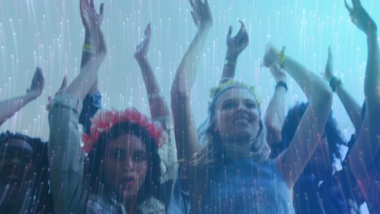 Duas mulheres na frente movendo-se ao ritmo da música, levantando os braços, sorrindo e aplaudindo sob chuva translúcida.