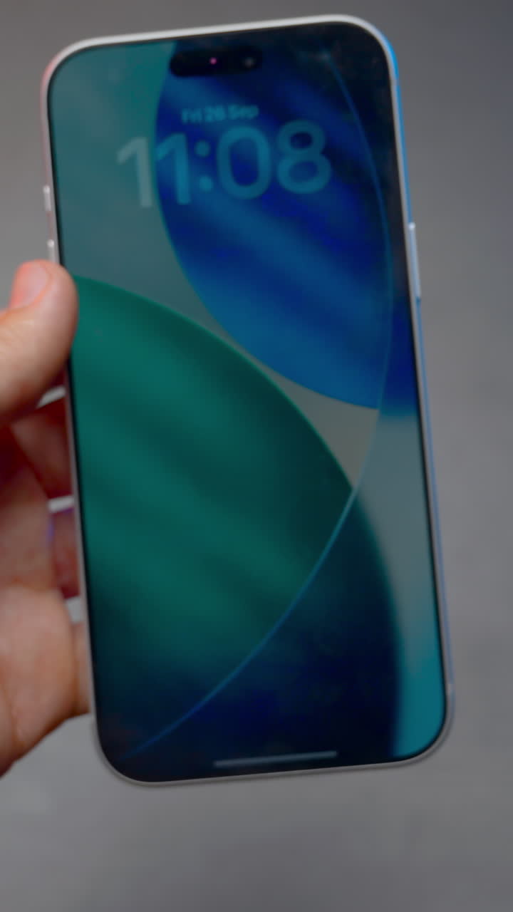 Mano maschile che tiene e ruota un nuovo concept smartphone, mostrandone i lati anteriore e posteriore.