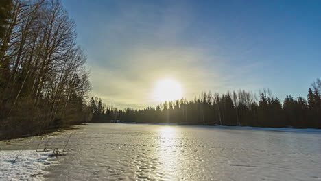 Toma-Estática-Del-Lago-Congelado-Rodeado-De-Bosque-En-Un-Día-Nublado-Con-Nubes-Blancas-Pasando-En-Timelapse