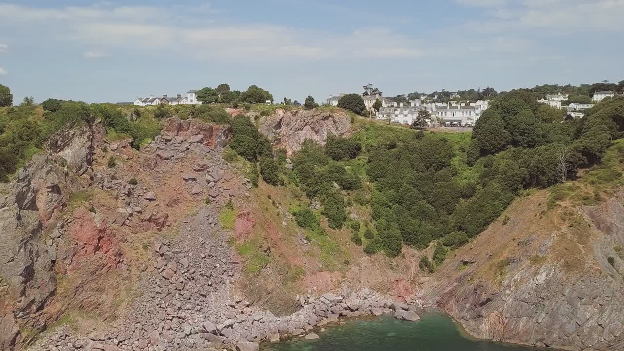 작은 마을이 내려다보이는 거대한 절벽으로 향하는 공중 촬영