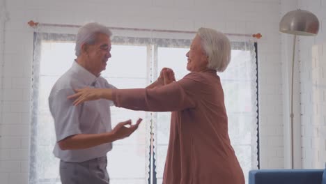 una pareja feliz bailando en casa.