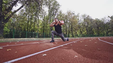 sportsman training in the stadium. strong athlete holding ten kg weight on back and doing his workout outdoors. slow motion.