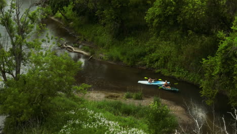 kayak canoes people paddling on small creek pushed by current in zumbro river