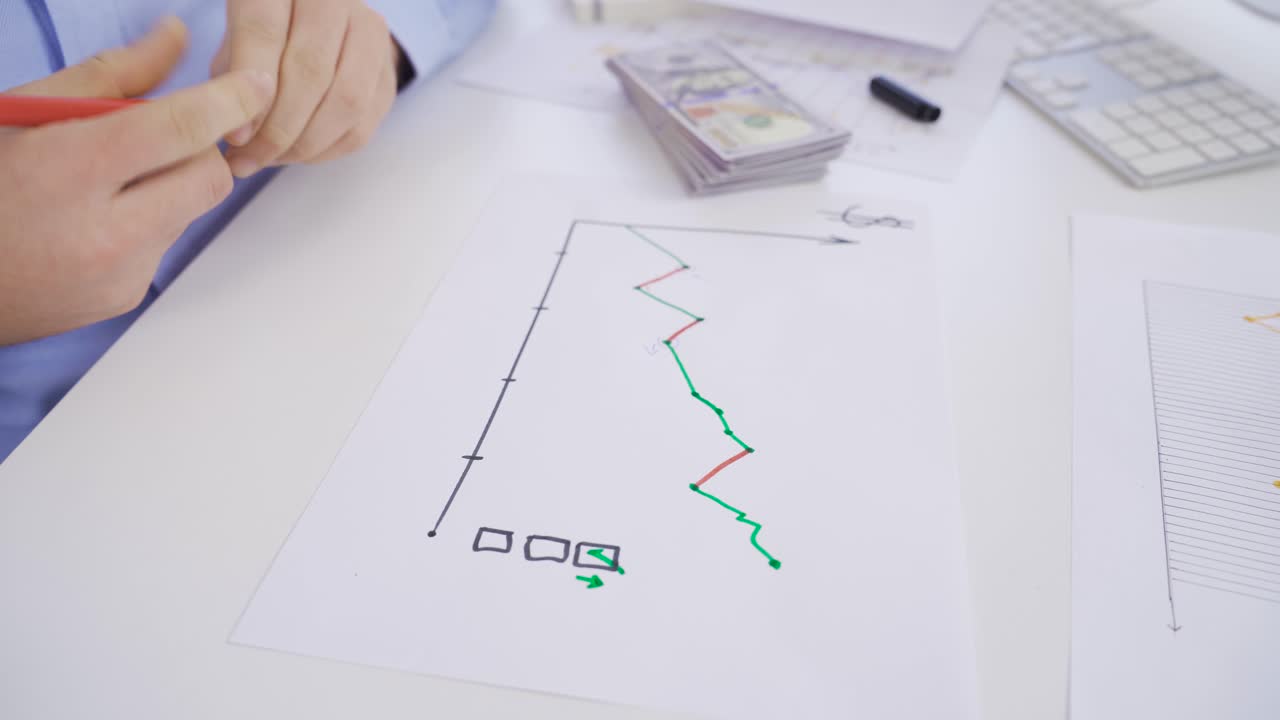 남자 손으로 통화 차트를 분석하고 있습니다.