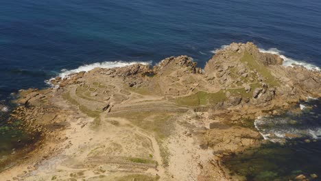 waves from the atlantic ocean crashing against rocks of castro de baroña