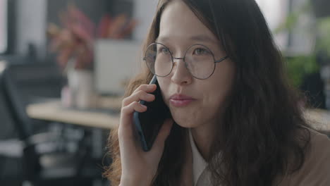 young woman talking on phone in office