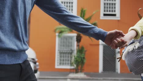 Focus-on-Caucasian-couple-on-the-go-holding-their-hands-during-coronavirus-pandemic