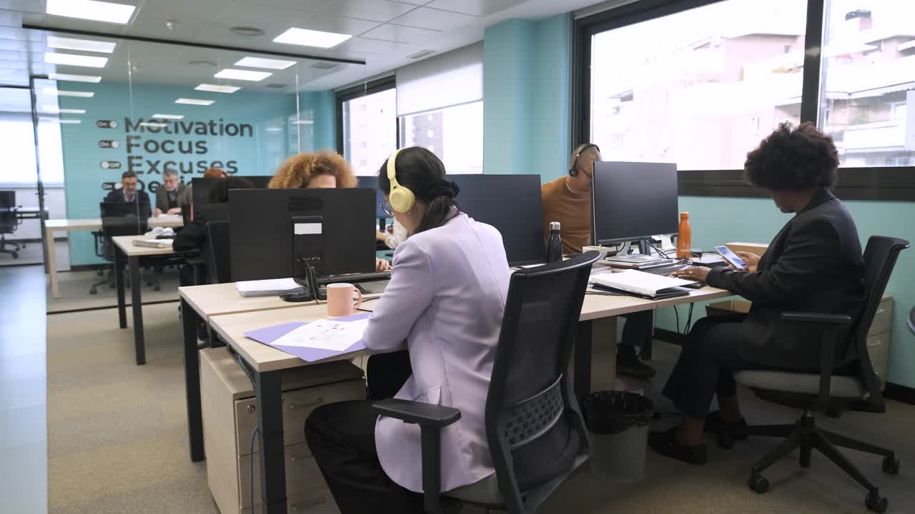 Empresarios ocupados trabajando en escritorios frente al ordenador en una oficina creativa