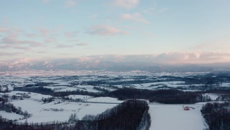 Snow-covered-fields-and-forests-of-Iwanai,-Hokkaido-at-sunrise