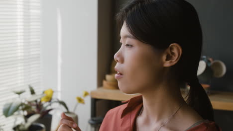 young woman enjoying takeout meal with chopsticks at home