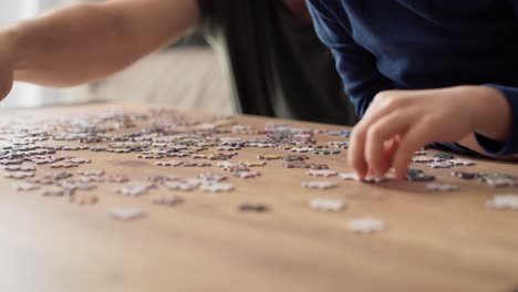 close up video of father  solving jigsaw puzzle with son