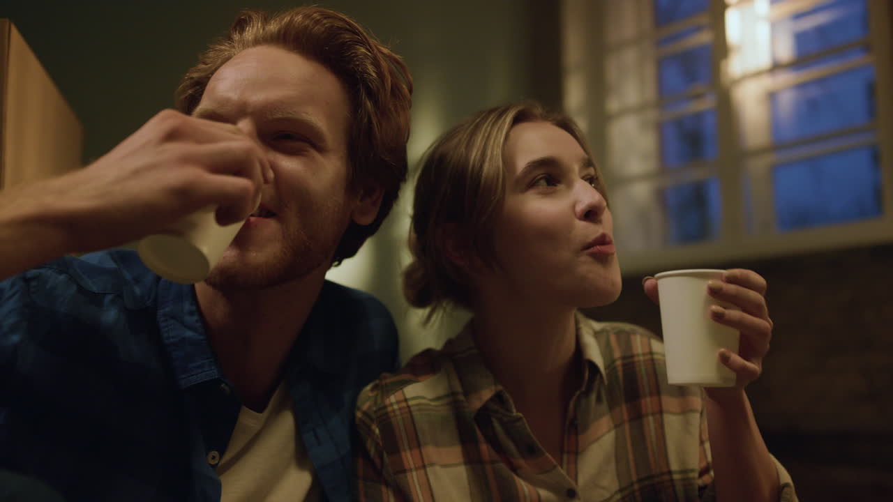 una familia alegre bebiendo café en un nuevo apartamento, una pareja disfrutando de la renovación de su casa.