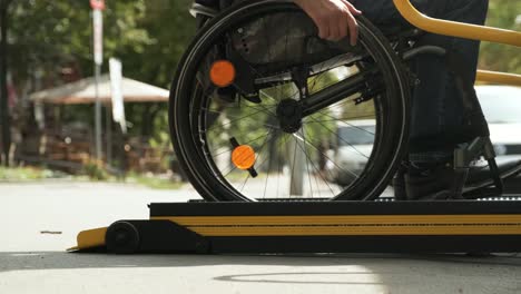 a man in a wheelchair on a lift of a vehicle for people with disabilities. lifting equipment for people with disabilities - man in wheelchair near the vehicle