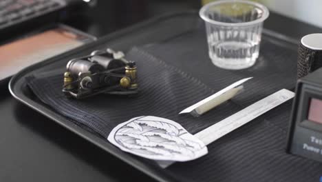 tattoo machine and pattern on working table in a tattoo art studio. close up