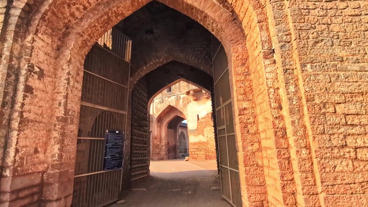 Arco d'ingresso del forte della Porta Sherja Darwaza con vecchie porte di legno e Sharza Darwaza al forte di Bidar, Karnataka, India. Di giorno, ripresa zib, ripresa a mano, 4k