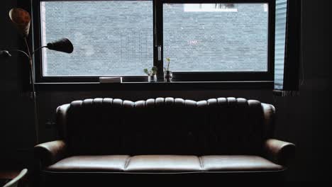 leather couch under window with shades drawn