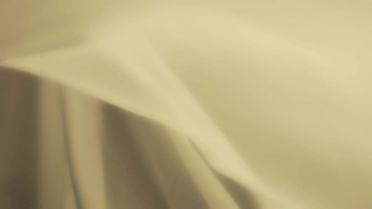 Abstract background of pastel yellow chiffon textile waving in the wind