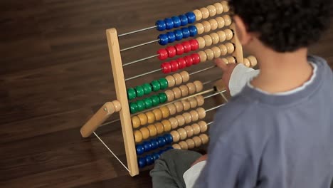 little boy playing with abacus toy at school stock footage