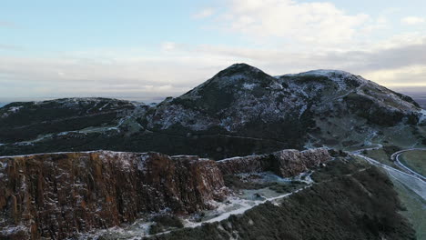 Aerial-view-flying-over-Arthurs-seat-in-Edinburgh-on-a-snowy-day