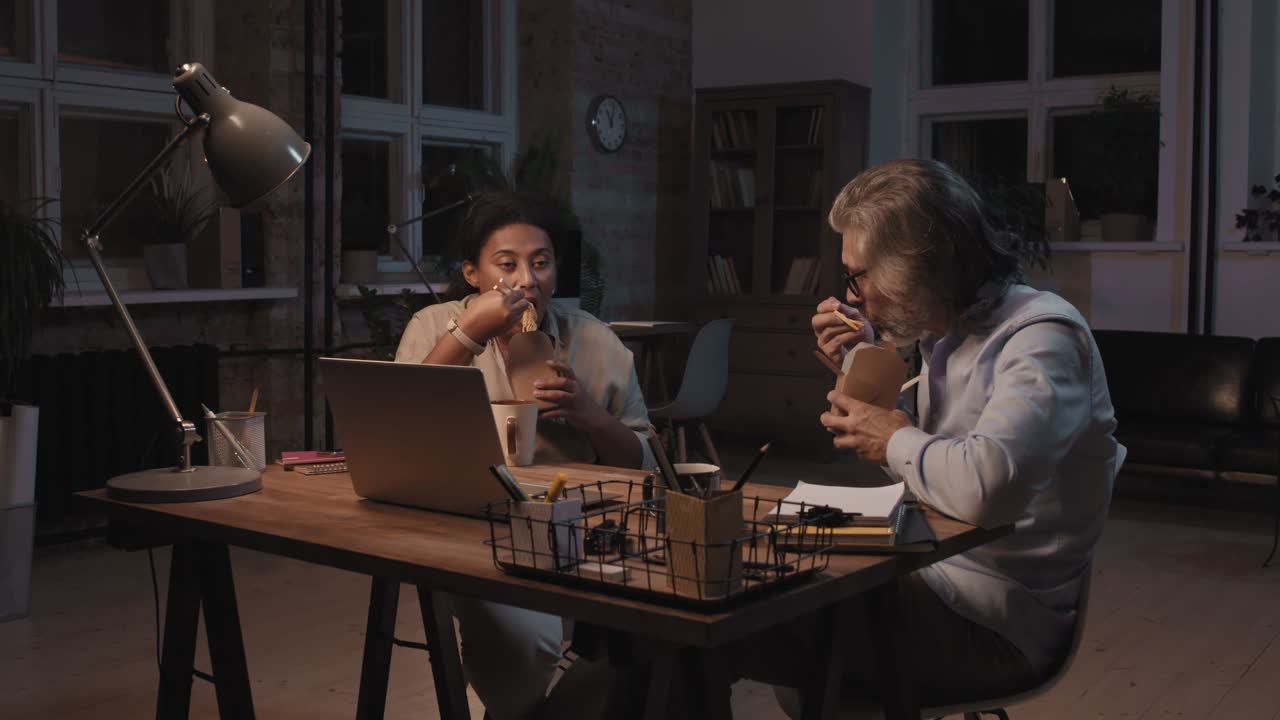 Two Coworkers Eat Food And Talk While Taking A Break 2