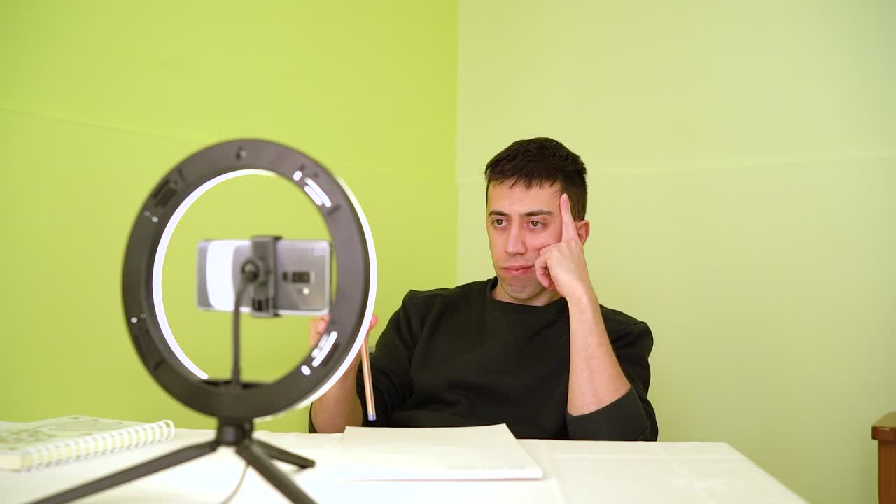 온라인 수업에 참석하는 동안 지루해지는 젊은 남자 - 중간