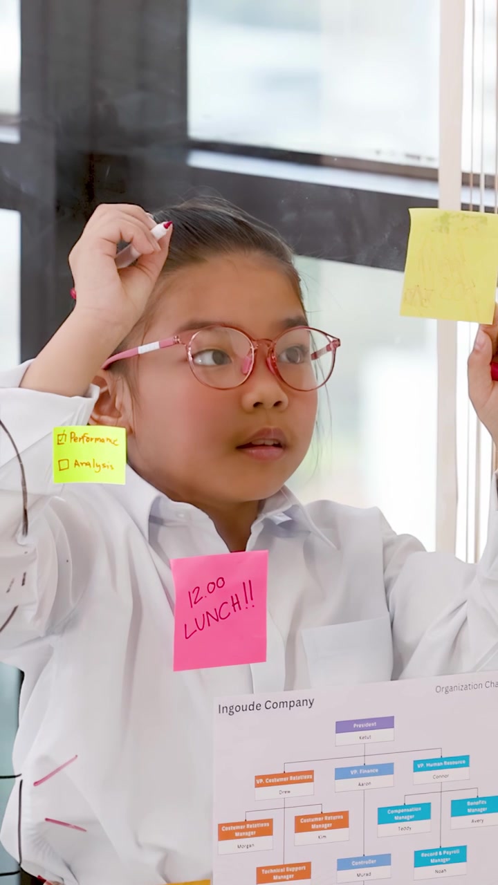 Gadis muda berbusana bisnis menggunakan catatan tempel dan spidol untuk curah pendapat strategi kantor yang kreatif.