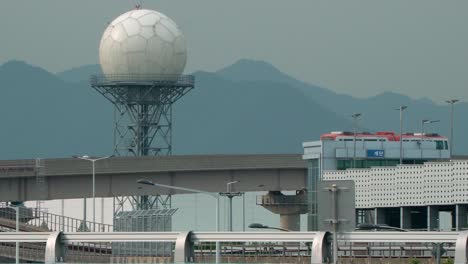 bus traveling in the overpass at the busan airport with a spherical radar antenna on the backdrop