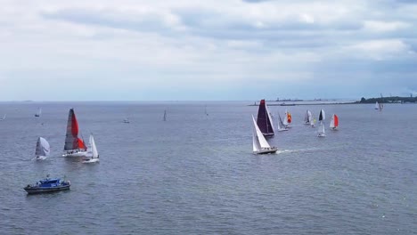 aerial view of sailboat regatta in a sea under a cloudy sky