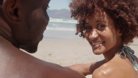 Woman-looking-at-camera-on-beach-in-the-sunshine-4k