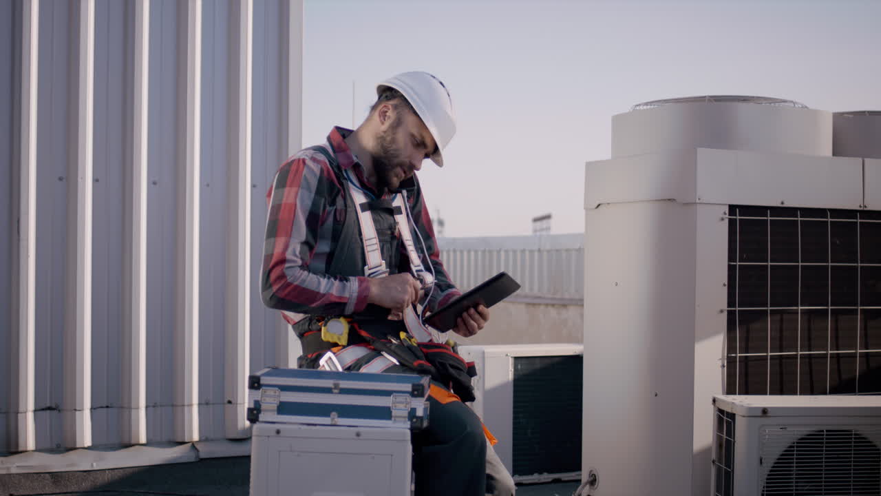 Technician Inspecting Rooftop Air Conditioning Unit