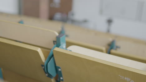 pan left across empty wooden tables in lecture theatre