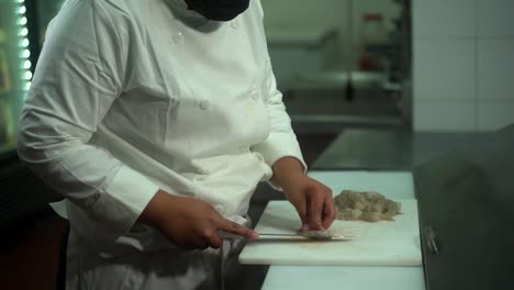 latin chef cleaning shrimps in industrial kitchen slow motion