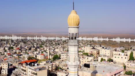 aerial view of a mosque in a middle eastern town with audio visual overlay