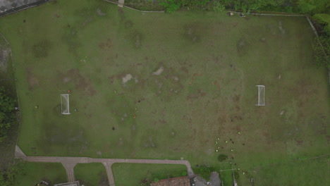 imágenes aéreas de arriba hacia abajo de un grupo jugando fútbol en un campo