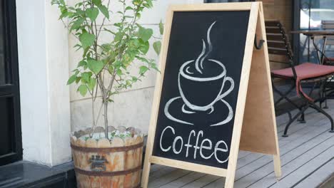 letrero de cafetería al aire libre con planta