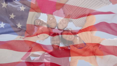 Animation-of-waving-flag-of-america-over-diverse-friends-celebrating-embracing-in-sun