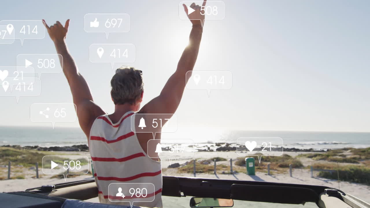 Man raising arms in convertible facing ocean, showing social media icons in marketing content
