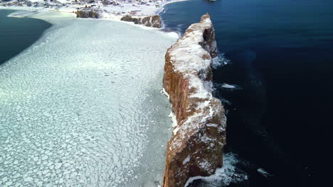 Luftaufnahme-Des-Percé-Felsens-Im-Winter-Mit-Eis-Auf-Dem-Ozean