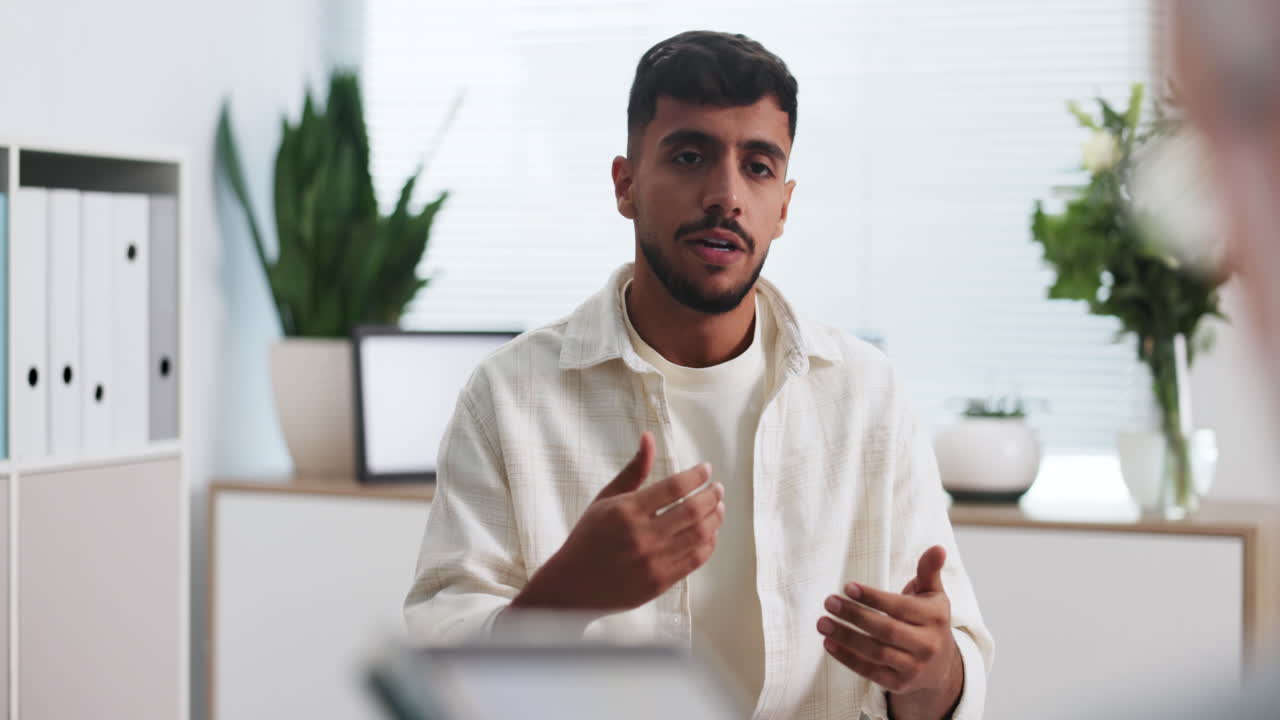 Young Man Talking and Gesturing During a Business Conversation