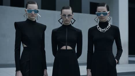 futuristic fashion showcase: three models dressed in sleek black attire with bold accessories and modern sunglasses, capturing a unique blend of style and confidence
